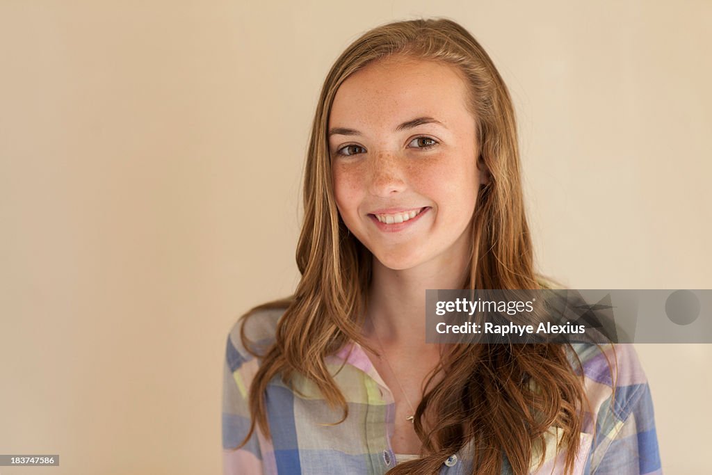 Portrait of teenage girl with long brown hair, smiling