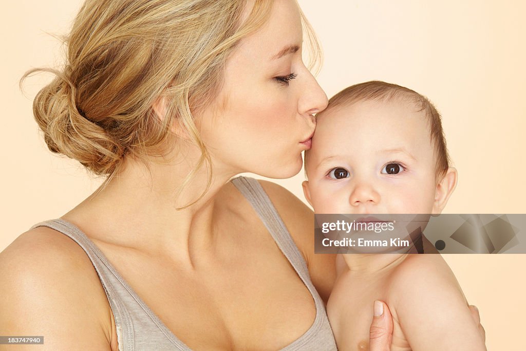 Mother kissing baby son on head