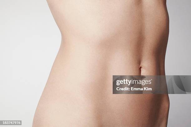 slim young woman's midriff - young women no clothes stock pictures, royalty-free photos & images