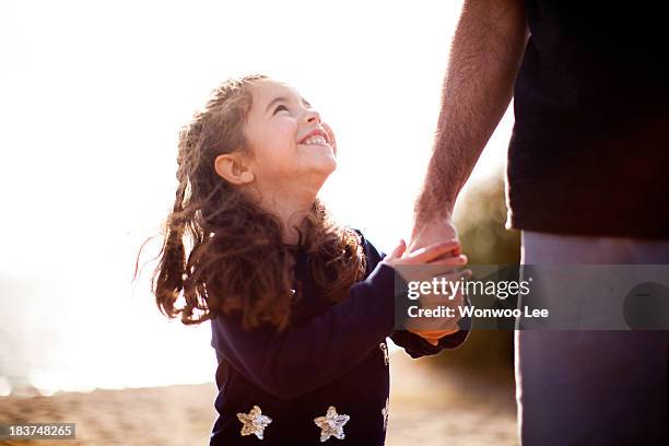 girl holding father's hand, looking up - bewondering stockfoto's en -beelden