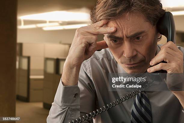 frowning man on telephone - cadalpe stock pictures, royalty-free photos & images