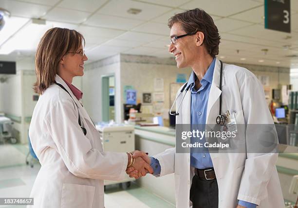 two doctors shaking hands - cadalpe stock pictures, royalty-free photos & images