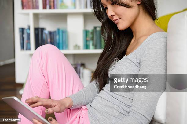 woman surfing the internet on digital tablet - woman jogging pants stock pictures, royalty-free photos & images