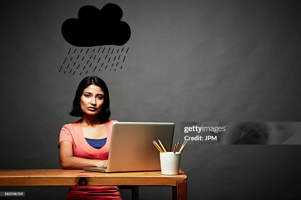 Woman sitting under dark rain cloud
