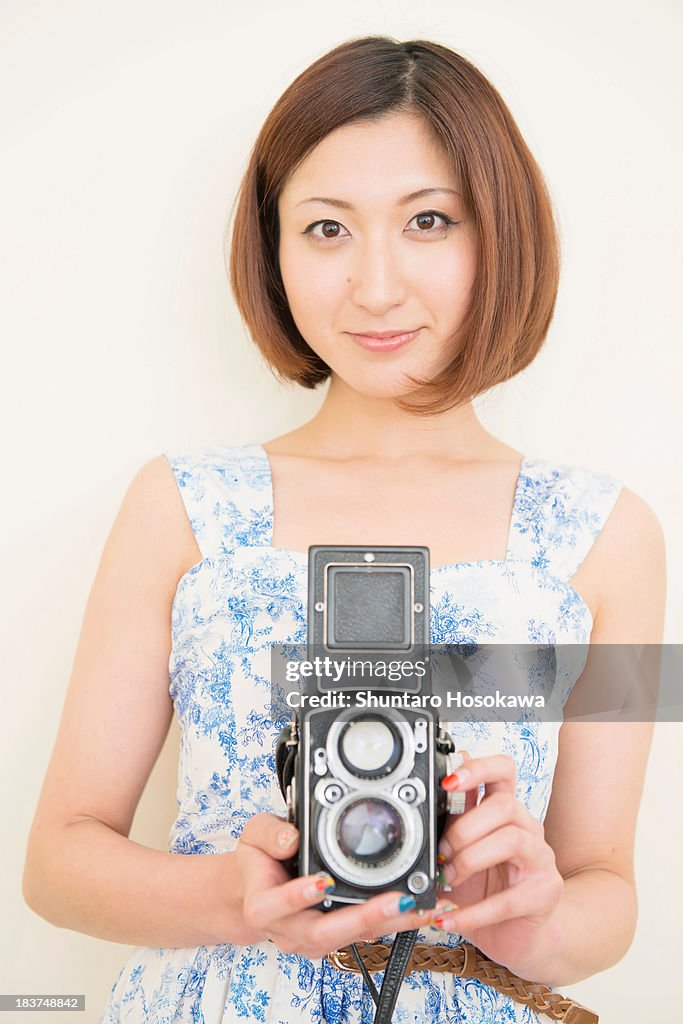 Smiling woman holding a 1960's classic camera