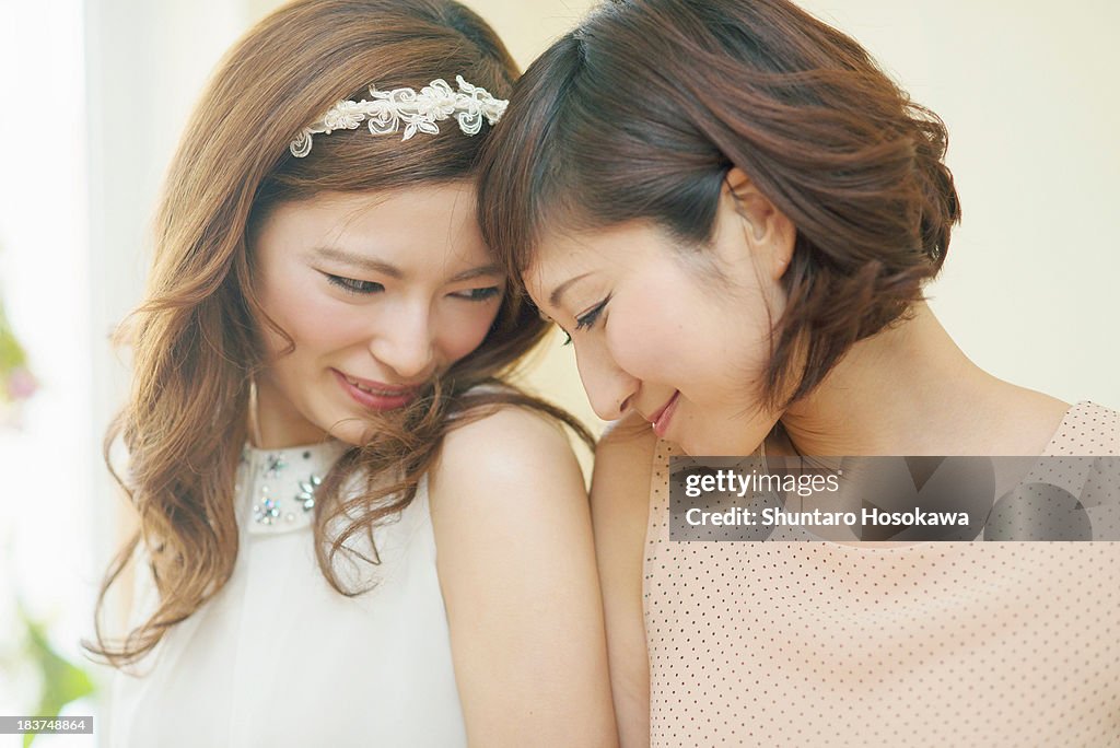 Two women nuzzling foreheads