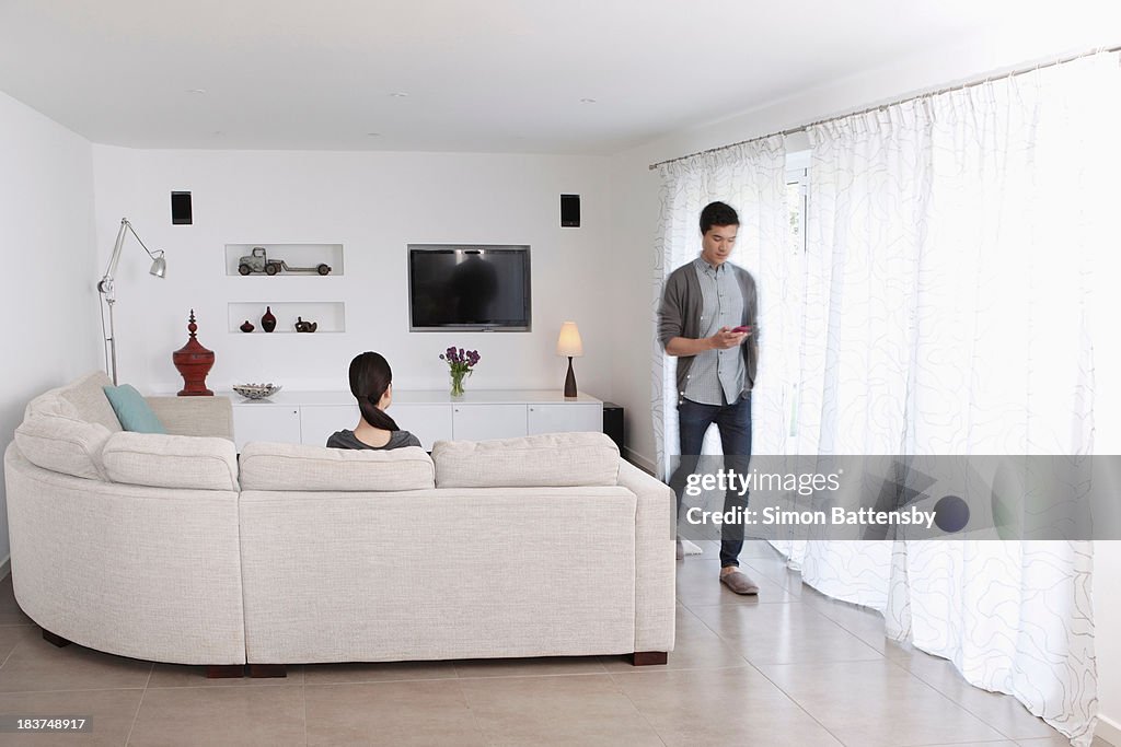 Woman looking at man walking away with mobile phone