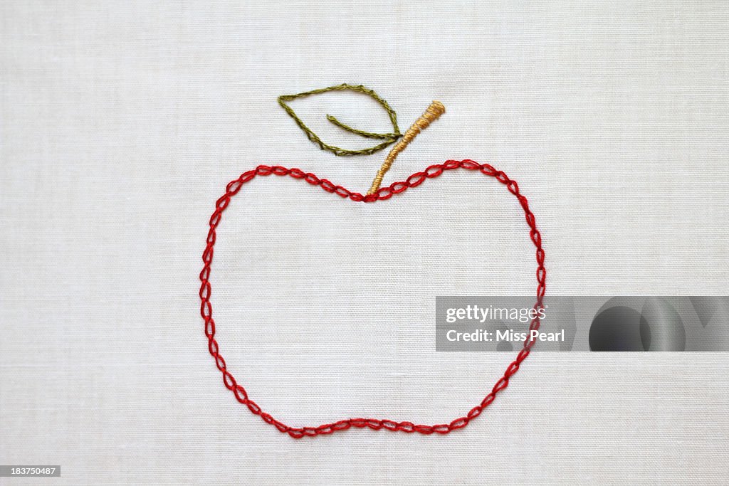 Apple symbol in red, green and gold embroidery