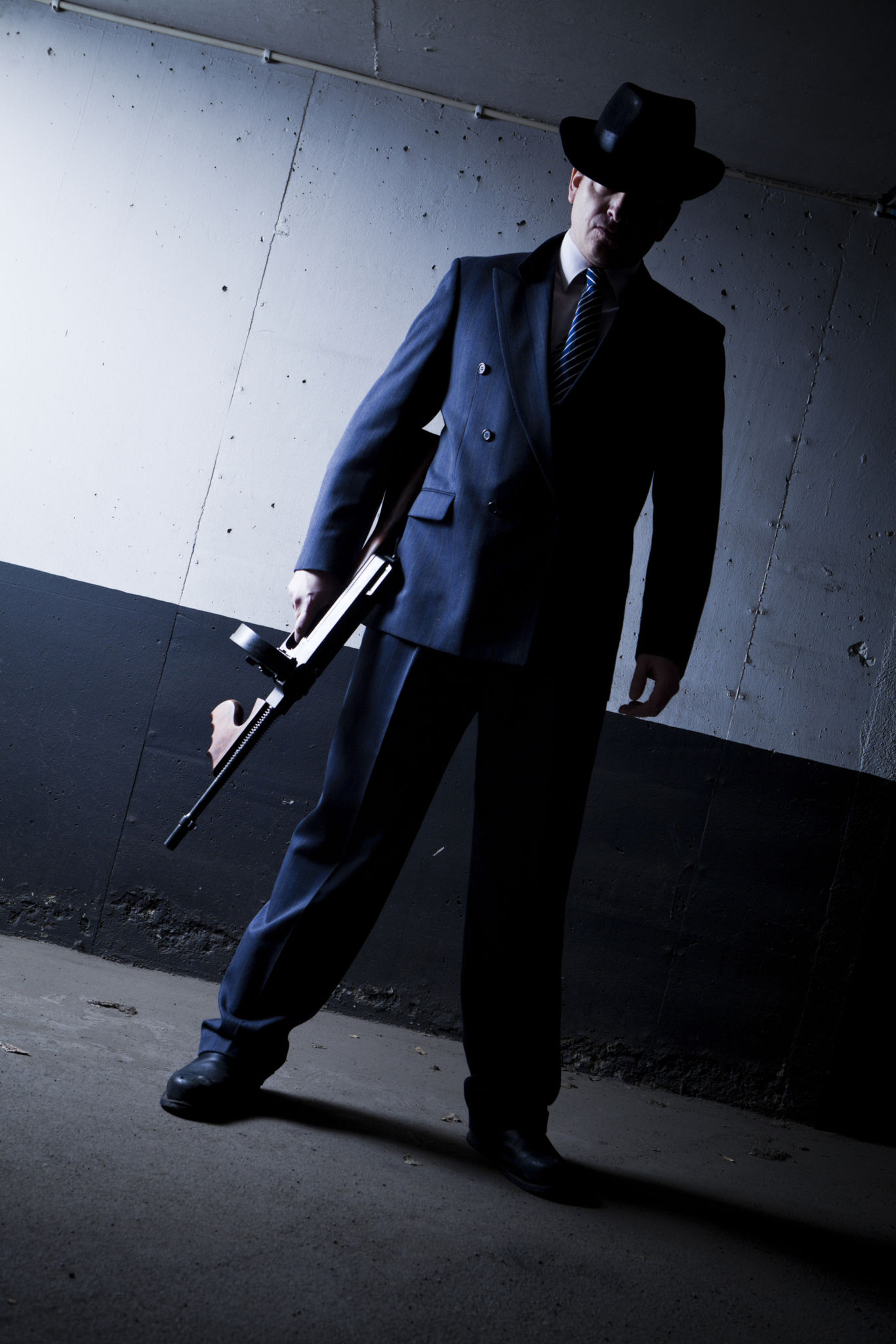 Old style gangster with tommy gun in dark setting Old style gangster with tommy gun in dark setting