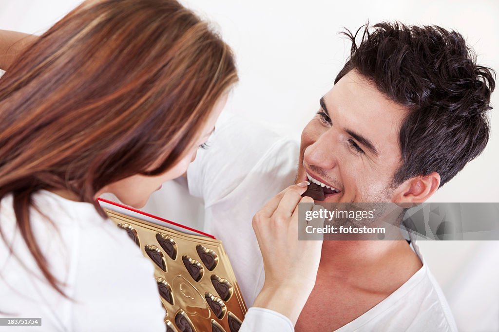 Woman giving chocolate candy to a man