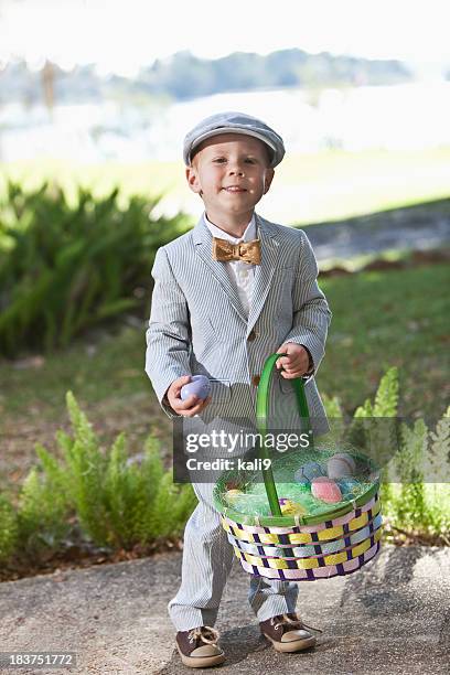 little boy in suit holding easter basket - easter hats stockfoto's en -beelden