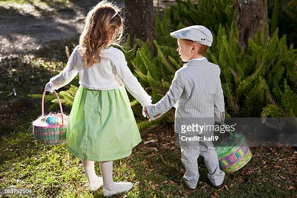 children on easter egg hunt - easter egg hunt outside stock pictures, royalty-free photos & images