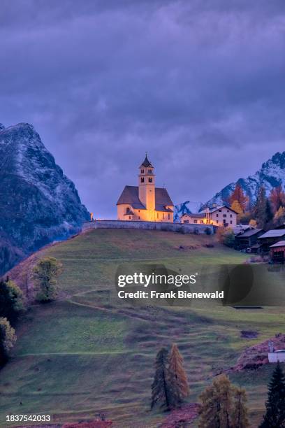 The church Chiesa Santa Lucia in Colle Santa Lucia at the foot of Giau Pass, Passo di Giau, illuminated at night in autumn . The entire Dolomites are...