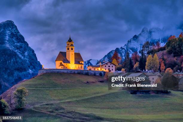The church Chiesa Santa Lucia in Colle Santa Lucia at the foot of Giau Pass, Passo di Giau, illuminated at night in autumn . The entire Dolomites are...