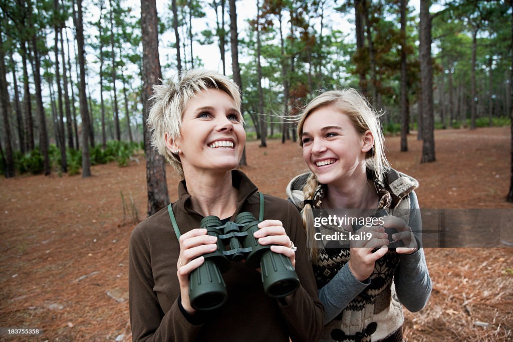 Mother and teen daughter enjoying scenic view with binoculars