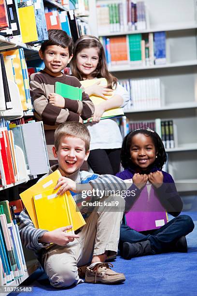 diverse group of young children in library - library kids stock pictures, royalty-free photos & images