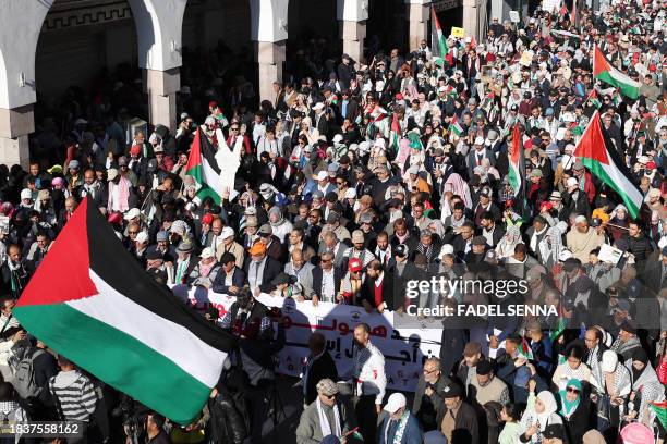 Moroccans wave Palestinian flags during a protest in Rabat on December 10, 2023 in solidarity with the Palestinians amid Israel's relentless...