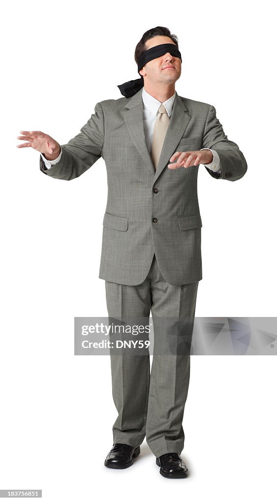 Blindfolded businessman extending hands isolated on white