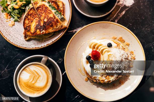 pancakes with banana and strawberry served for breakfast in a restaurant, high angle view - brunch imagens e fotografias de stock