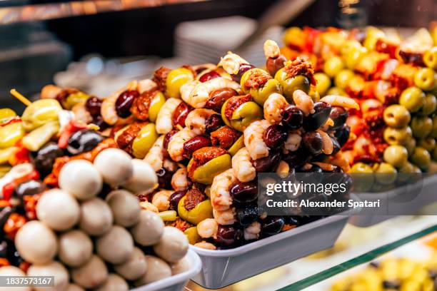 various tapas with olives, shrimp and dried tomato at mercado de san miguel market, madrid, spain - queso español fotografías e imágenes de stock