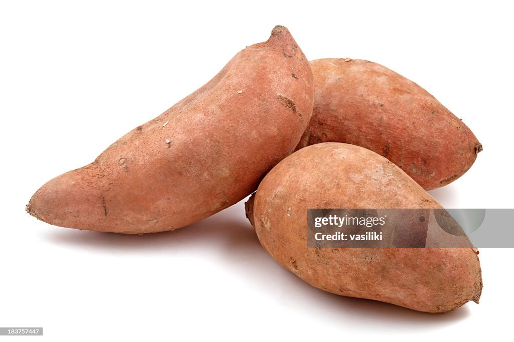 Close-up of three Raw sweet potatoes