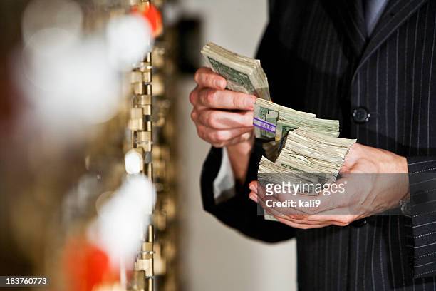 man with cash by safety deposit boxes - money laundering 個照片及圖片檔