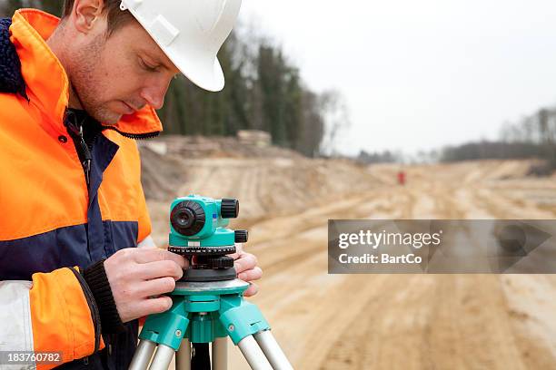 land surveyor on construction site the netherlands - wegenbouw stockfoto's en -beelden
