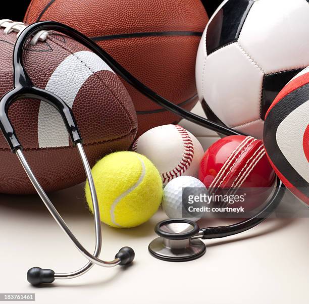 sports balls with stethescope - american football ball stock pictures, royalty-free photos & images