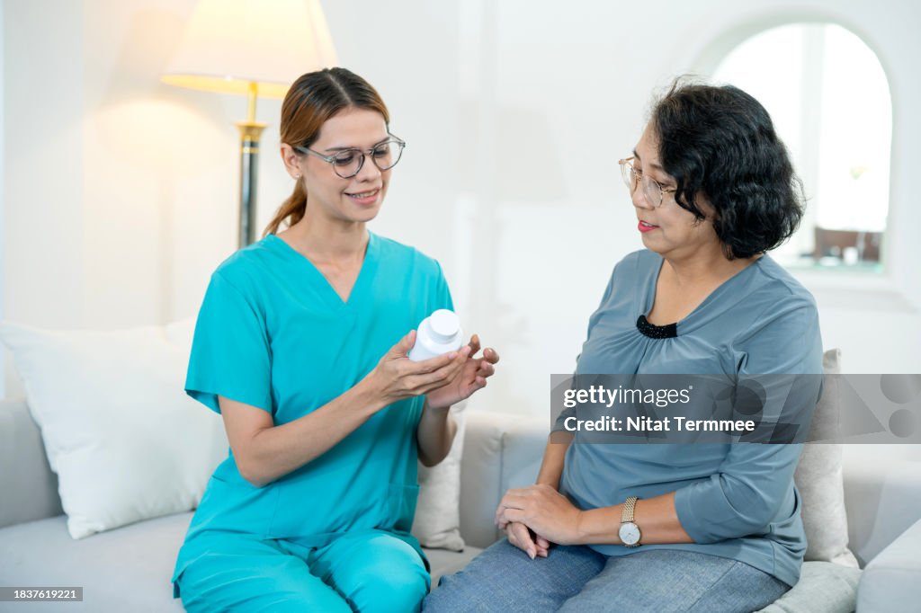 Taking Medicines Safely for Geriatrics. A female home nurse reviewing and guidance taking medicine for Parkinson disease with senior patients during a home visit.
