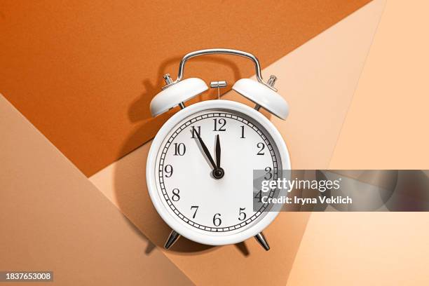 happy 2024 new year celebration with retro alarm clock and abstract geometric multicolor background with several layers of sheets of paper. - orange alarm clock stock pictures, royalty-free photos & images