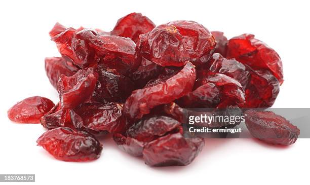 pile of dried shriveled red cranberries on white background - gedroogd voedsel stockfoto's en -beelden