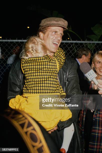 American actor Ted Danson carries his adopted daughter Alexis Danson as they attend a Cirque du Soleil performance at Santa Monica Pier in Santa...