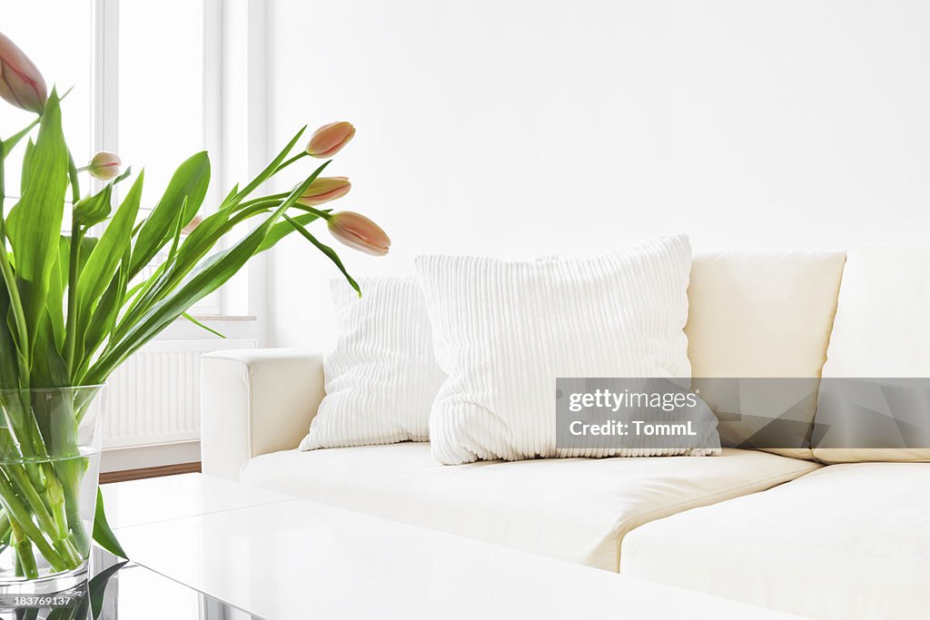 Un canapé blanc et tulipes dans une salle de séjour moderne