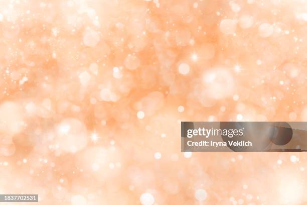 sparkling background with bokeh made of elegant christmas lights in color trend 2024 peach fuzz. - glitter fruit stock pictures, royalty-free photos & images