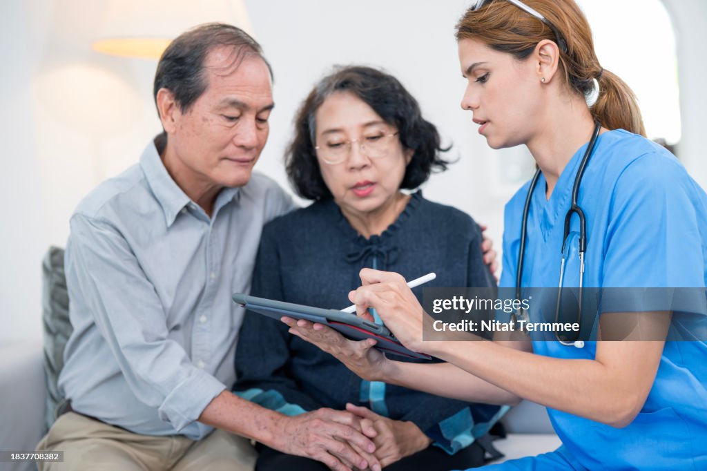 Home Care For Seniors and Family Caregivers to Reduce Lower Risk Of Loneliness And Isolation. A female nurse having in-home consultation a prescription medicine by a tablet computer with senior patients.