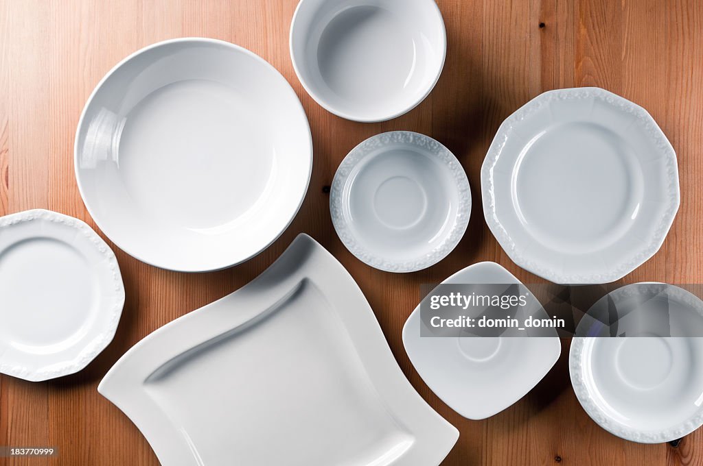 Group of elegant china, everyday ceramics tableware on wooden table