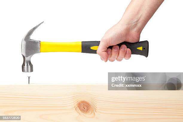 hand holding hammer hitting a nail in wood - hammer stock pictures, royalty-free photos & images