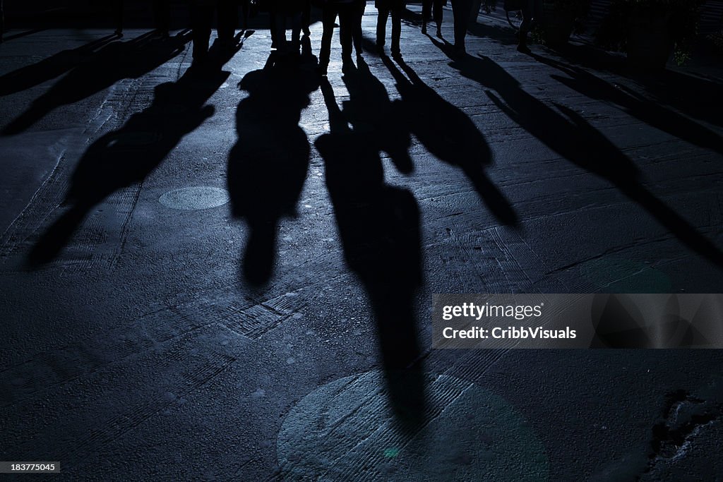 Grupo de pessoas fazendo avançar no visualizador azul noite as sombras