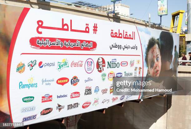Yemeni passersby walk near a billboard bearing a picture of a Palestinian child with a blood-stained face carried by a man after he was injured in an...
