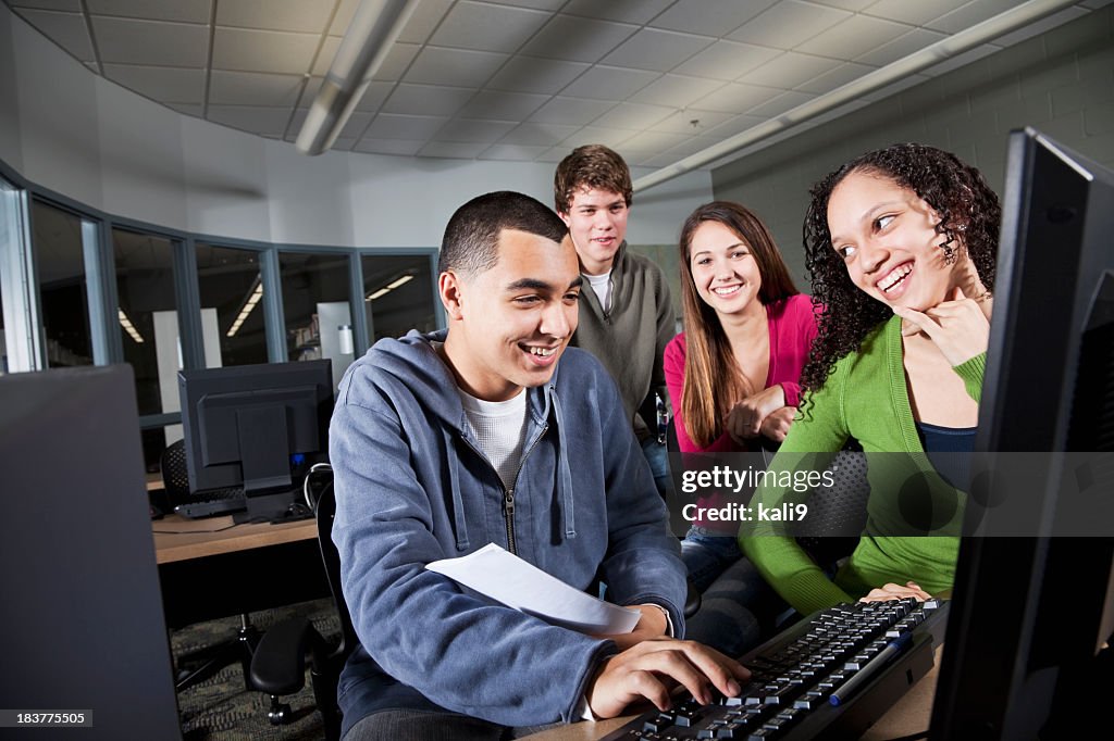 Group of teenage students using computer