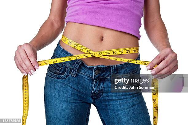 woman measuring her waist - loose women stock pictures, royalty-free photos & images