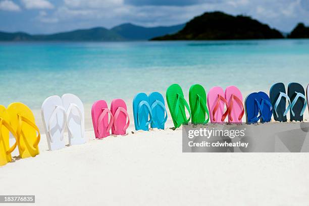 colorful family sandals in white sand on a caribbean beach - thongs on beach stockfoto's en -beelden