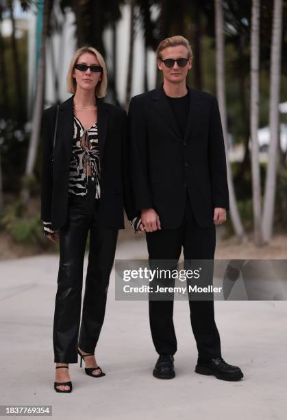 Ave Rohtla seen wearing black sunglasses, black / white transparent zebra pattern blouse, black blazer jacket, black leather straight leg pants,...