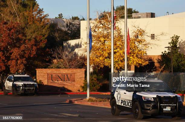 Flags fly at half-staff near police vehicles at the University of Nevada, Las Vegas campus the morning after a shooting left three dead on December...