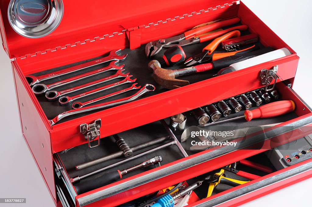 Red toolbox with open drawers and top full of tools 