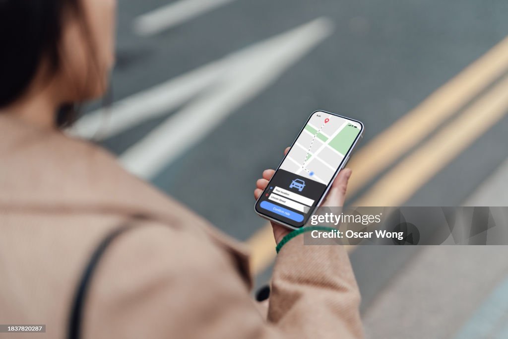 Young woman ordering taxi service via mobile app on smartphone