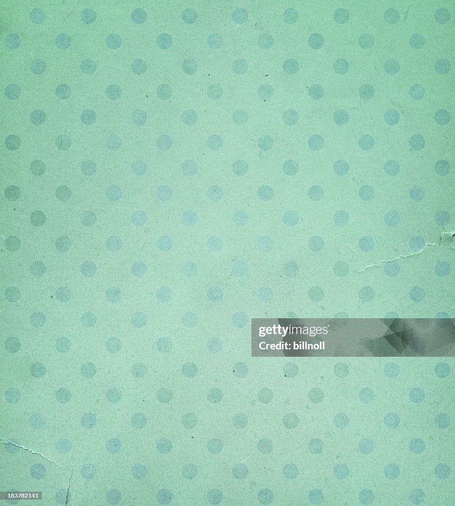 Torn green paper with faded dots