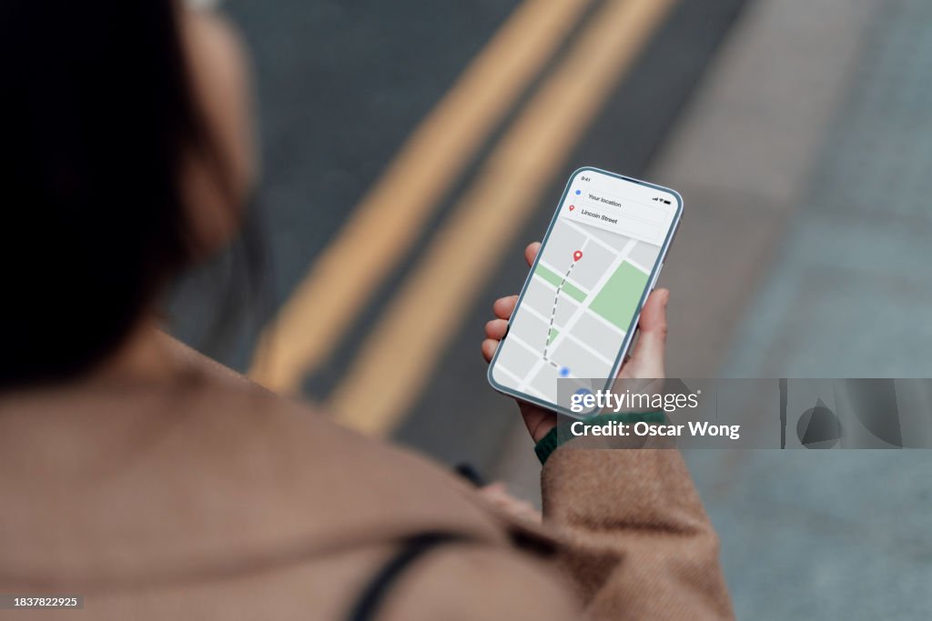 Young Asian woman using navigate app on smartphone to get direction