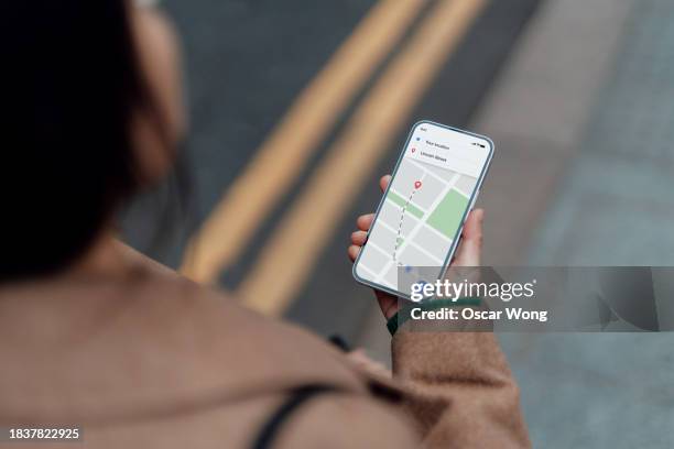 young asian woman using navigate app on smartphone to get direction - navigatieapparatuur stockfoto's en -beelden
