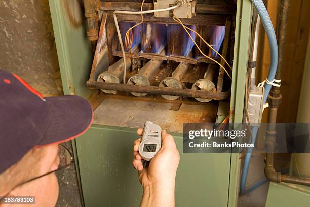 repairman with digital infrared thermometer checks gas furnace output temperature - home furnace stock pictures, royalty-free photos & images